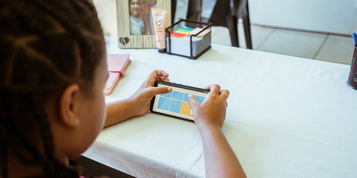 A student is enhancing her maths skills using iRainbow on a mobile device.