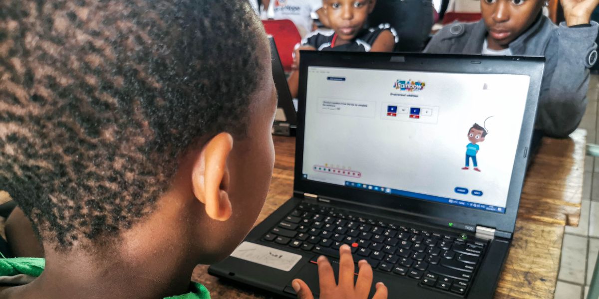 A student is improving his maths skills using iRainbow on a laptop.