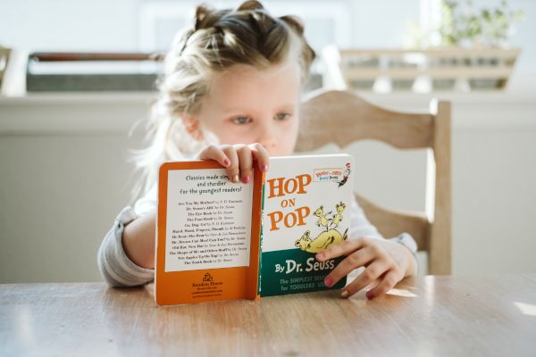 Child reading a book - showing the importance of teaching a child to think for themselves.