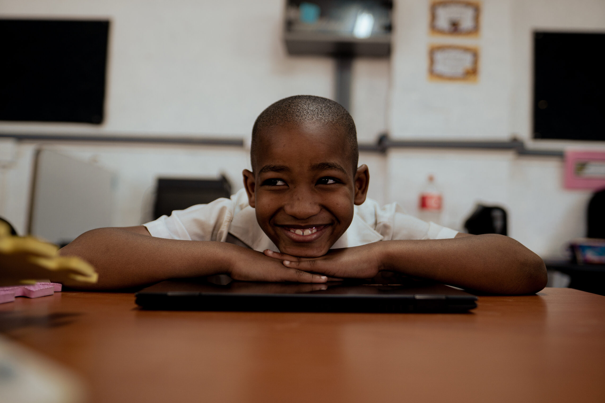 A grade seven student smiling with a laptop, mastering maths skills with iRainbow.