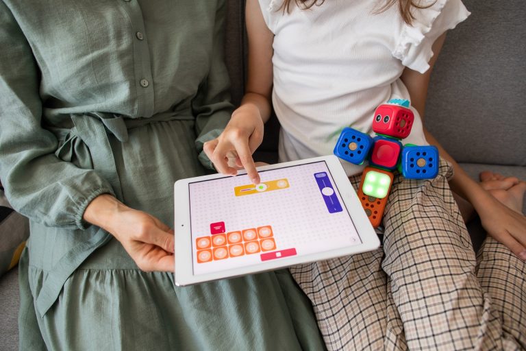 A women and child holding an educational software tablet