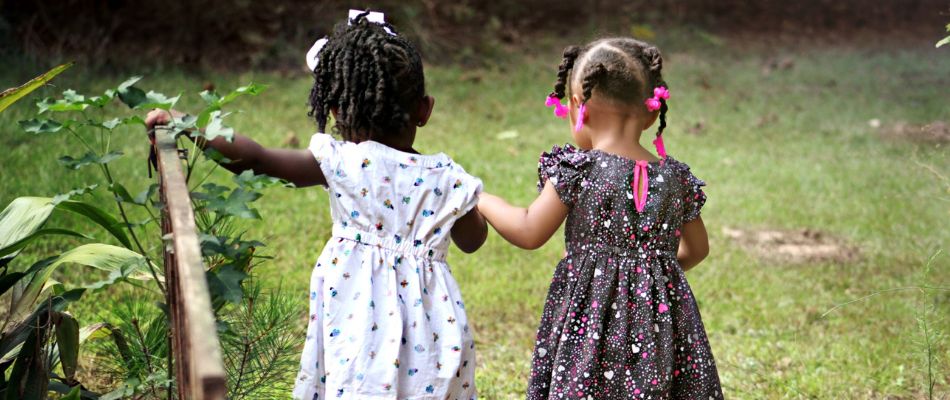 Two children are walking hand in hand, supporting each other to combat child bullying.