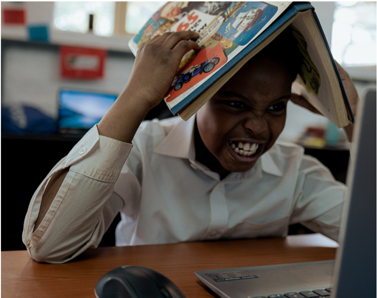 A child with a book on his head, struggling to learn