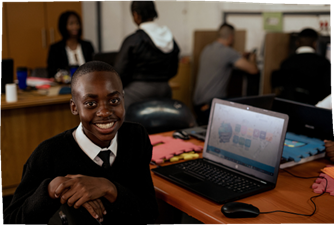A young learner sitting with a laptop using iRainbows offline education software