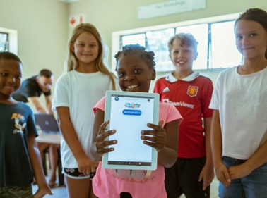 A girl holding the iRainbow tablet, with the iRainbow offline educational software
