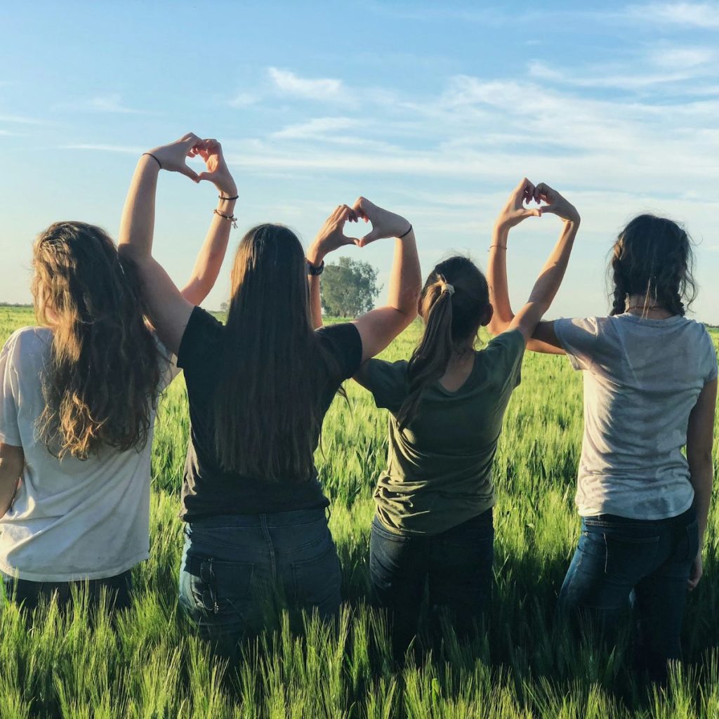 A group of girls holding hear signs, learning about empathy through Life Orientation