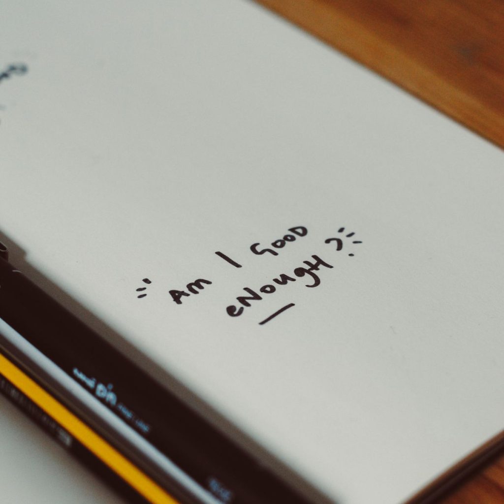A notebook stating Am I Good Enough